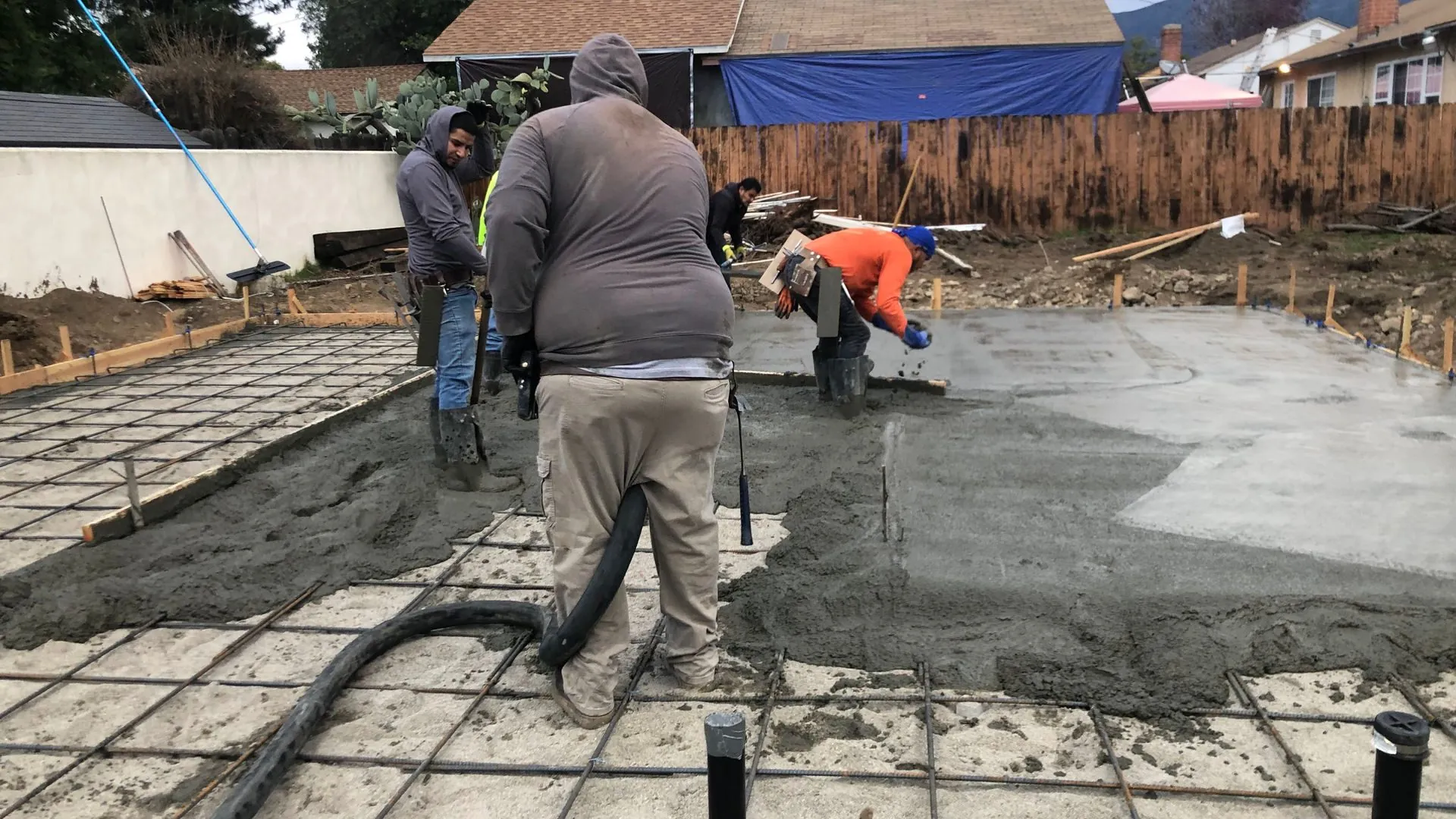 Crew placing and screeding a reinforced concrete slab over a rebar mat