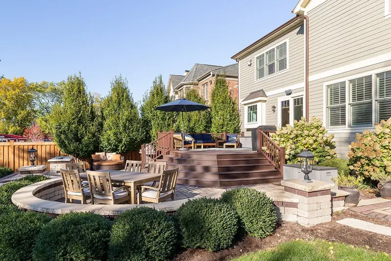 Multi-level paver patio with seat walls, raised deck and integrated planting beds