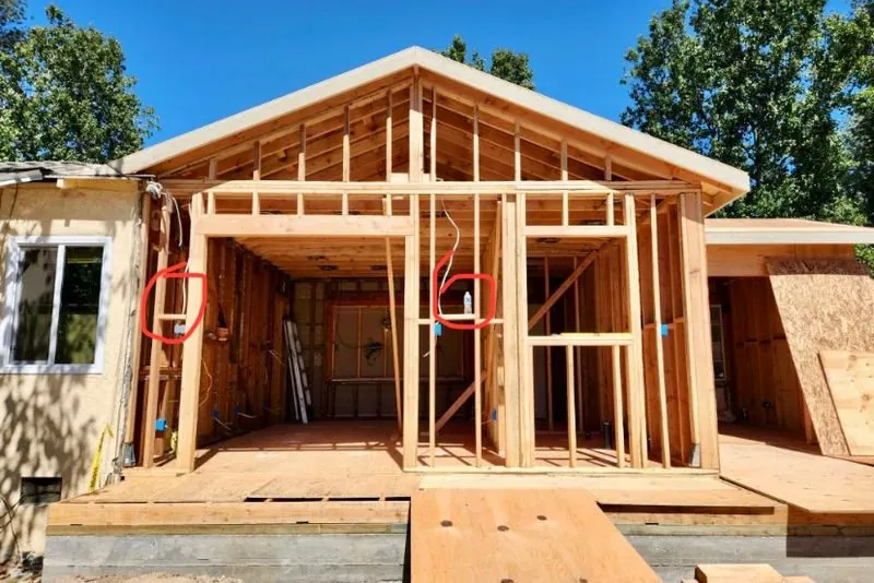 Gable-roof room addition framed onto an existing single-story house