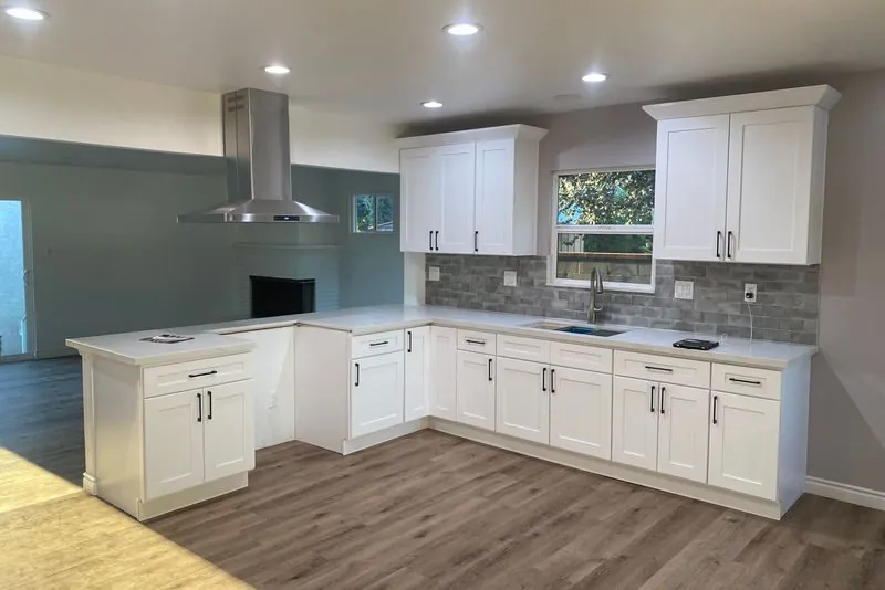 Completed kitchen remodel with white shaker cabinetry, stone counters and tile backsplash
