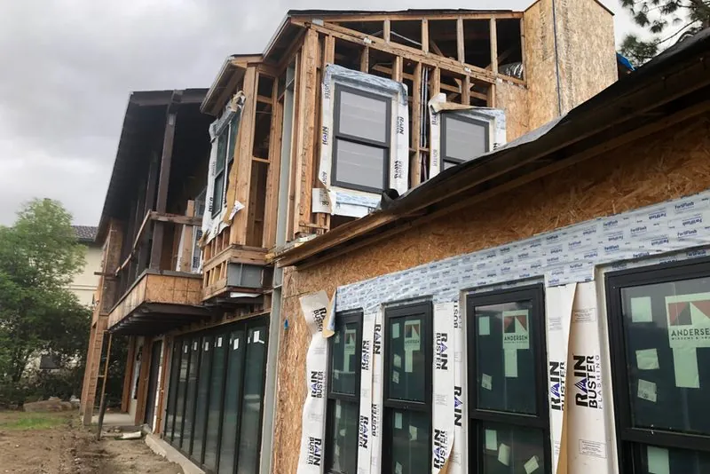 Framed multi-level residence with window openings set and building wrap installed